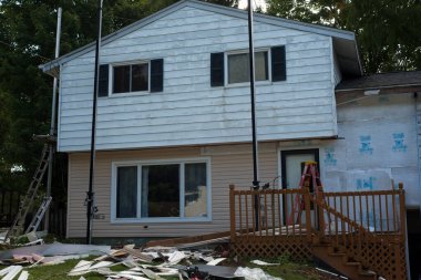 Twinsburg, OH, USA - 2 Ekim 2024: Eski alüminyum kaplama, alt kattaki yeni vinil kaplamayla çelişiyor..