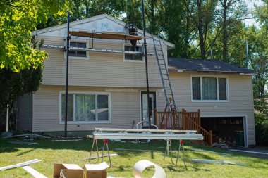 Twinsburg, OH, USA - 3 Ekim 2024: Bölünmüş bir banliyö evinin tepesi hariç her yere yeni kaplama döşenmiş bir ev yenileme projesi tamamlanmak üzere.