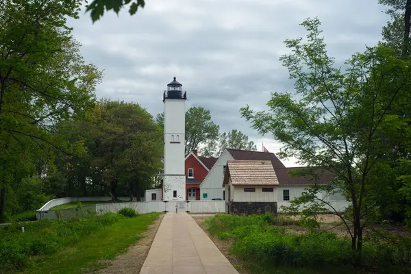Pennsylvania, Erie Gölü 'ndeki Presque Adası Eyalet Parkı' ndaki eski deniz feneri ve bitişik yapılar baharın sonlarında bulutlu gökyüzünün altında.