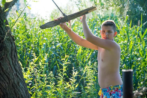 一个少年以滑稽的姿势在绳子上荡秋千 准备在阳光灿烂的夏日跳入水中 — 图库照片
