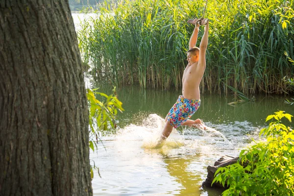 Dospívající Chlapec Houpe Laně Legrační Póze Připraven Skočit Vody Slunečného — Stock fotografie