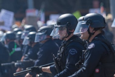 Los Angeles, ABD 8 Haziran 2025 LAPD memuru şehir merkezindeki göçmen haklarına destek ve genişletilmiş ICE operasyonlarına karşı gözcülük yapıyor..