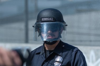 Los Angeles, ABD 8 Haziran 2025 LAPD memuru şehir merkezindeki göçmen haklarına destek ve genişletilmiş ICE operasyonlarına karşı gözcülük yapıyor..
