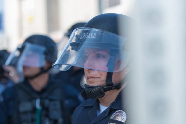 Los Angeles, ABD 8 Haziran 2025 LAPD memuru şehir merkezindeki göçmen haklarına destek ve genişletilmiş ICE operasyonlarına karşı gözcülük yapıyor..