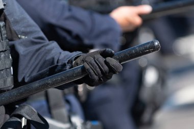 Los Angeles, ABD 8 Haziran 2025 'te şehir merkezindeki göçmen haklarına destek ve genişletilmiş göçmen haklarına karşı düzenlenen bir gösteride polis copu tutan polis memurunun yakın çekimi.