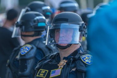 Los Angeles, ABD 8 Haziran 2025 LAPD memuru şehir merkezindeki göçmen haklarına destek ve genişletilmiş ICE operasyonlarına karşı gözcülük yapıyor..