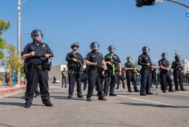 Los Angeles, ABD 8 Haziran 2025 LAPD memurları genişletilmiş göçmen haklarına karşı düzenlenen bir gösteride nöbet tutuyorlar..