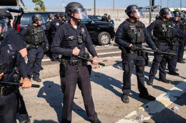 Los Angeles, ABD 8 Haziran 2025 LAPD memurları genişletilmiş göçmen haklarına karşı düzenlenen bir gösteride nöbet tutuyorlar..