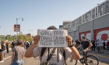 Los Angeles, ABD 8 Haziran 2025. Adam şehir merkezindeki göçmen haklarına destek ve genişletilmiş göçmen operasyonlarına karşı düzenlenen gösteride elinde bir İncil 'le protesto işareti tutuyor..