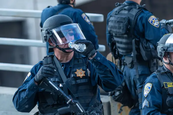 Los Angeles, ABD 8 Haziran 2025 LAPD memuru şehir merkezindeki göçmen haklarına destek ve genişletilmiş ICE operasyonlarına karşı gözcülük yapıyor..