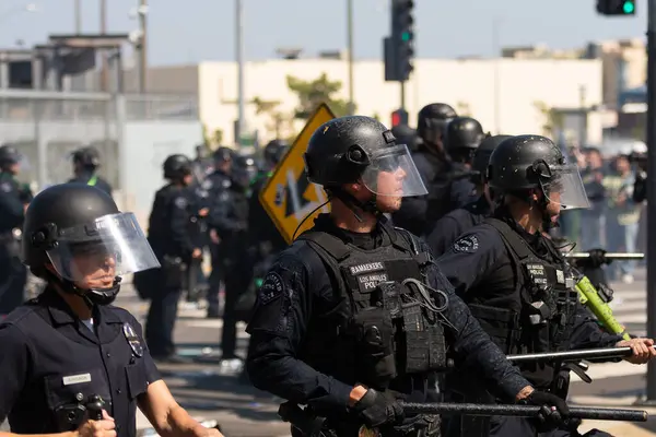 Los Angeles, ABD 8 Haziran 2025 LAPD memurları genişletilmiş göçmen haklarına karşı düzenlenen bir gösteride nöbet tutuyorlar..