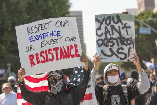 Los Angeles, ABD 8 Haziran 2025 Erkekler şehir merkezindeki göçmen haklarına destek ve genişletilmiş ICE operasyonlarına karşı protesto işareti tutuyorlar..