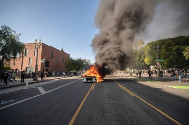 Los Angeles, ABD, 8 Haziran 2025. Otomatik elektrikli otomobiller, genişletilmiş ICE operasyonlarına ve göçmen haklarına karşı düzenlenen bir gösteride yakıldı..