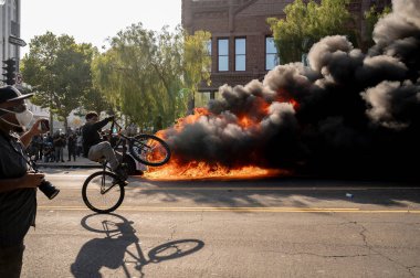 Los Angeles, ABD, 8 Haziran 2025. Otomatik elektrikli otomobiller, genişletilmiş ICE operasyonlarına ve göçmen haklarına karşı düzenlenen bir gösteride yakıldı..