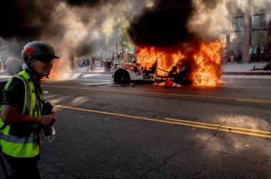 Los Angeles, ABD, 8 Haziran 2025. Otomatik elektrikli otomobiller, genişletilmiş ICE operasyonlarına ve göçmen haklarına karşı düzenlenen bir gösteride yakıldı..