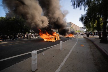 Los Angeles, ABD, 8 Haziran 2025. Otomatik elektrikli otomobiller, genişletilmiş ICE operasyonlarına ve göçmen haklarına karşı düzenlenen bir gösteride yakıldı..