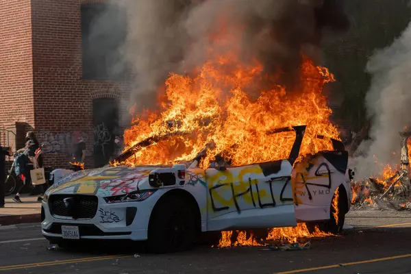 Los Angeles, ABD, 8 Haziran 2025. Otomatik elektrikli otomobiller, genişletilmiş ICE operasyonlarına ve göçmen haklarına karşı düzenlenen bir gösteride yakıldı..