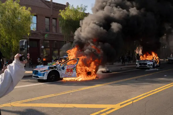 Los Angeles, ABD, 8 Haziran 2025. Otomatik elektrikli otomobiller, genişletilmiş ICE operasyonlarına ve göçmen haklarına karşı düzenlenen bir gösteride yakıldı..