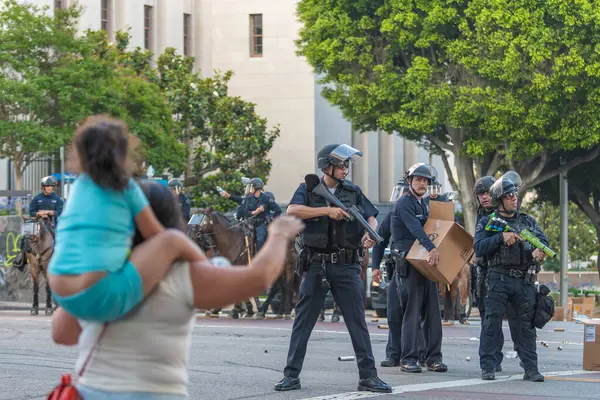 Los Angeles, ABD, 8 Haziran 2025 Annesi, şehir merkezindeki genişletilmiş ICE operasyonlarına karşı yürütülen ve göçmen haklarına destek veren bir gösteride polis memuruna sloganlar attı.