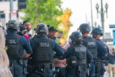Los Angeles, ABD, 8 Haziran 2025 Polis memurları, göçmen haklarına destek ve genişletilmiş ICE operasyonlarına karşı düzenlenen bir gösteride insanların etrafını sardı.