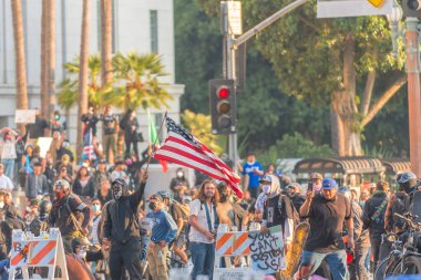 Los Angeles, ABD, 8 Haziran 2025. İ.T. operasyonlarının genişletilmesine ve göçmen haklarının desteklenmesine karşı düzenlenen bir gösteride Amerikan bayrağı taşıyan protestocu