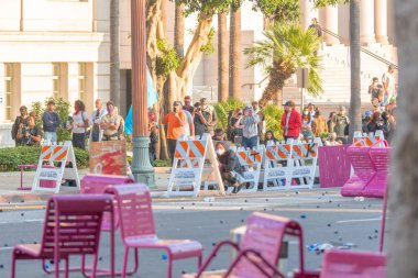 Los Angeles, ABD, 8 Haziran 2025. İCE operasyonlarının genişletilmesi ve göçmen haklarına destek gösterileri sırasında park banklarıyla kurulan geçici barikatların arkasına sığınan protestocular,
