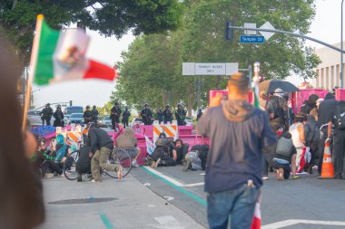 Los Angeles, ABD, 8 Haziran 2025. İCE operasyonlarının genişletilmesi ve göçmen haklarına destek gösterileri sırasında park banklarıyla kurulan geçici barikatların arkasına sığınan protestocular,