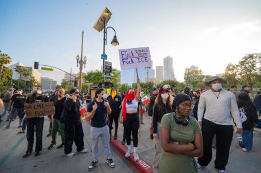 Los Angeles, ABD, 8 Haziran 2025. Ellerinde tabela olan protestocular, genişletilmiş ICE operasyonlarına ve göçmen haklarına karşı düzenlenen bir gösteride slogan attı.
