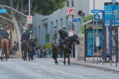 Los Angeles, ABD, 8 Haziran 2025: Ata binmiş polis memuru, göçmen haklarına destek ve genişletilmiş göçmen haklarına karşı şehir merkezinde düzenlenen bir gösteri sırasında emir veriyor