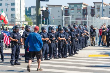 Los Angeles, ABD, 8 Haziran 2025: Los Angeles polis memurları, genişletilmiş ICE operasyonlarına ve göçmen haklarına karşı düzenlenen bir gösteride protestocularla karşı karşıya
