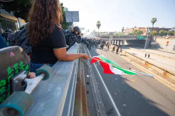 Los Angeles, ABD, 8 Haziran 2025: İCE operasyonlarının genişletilmesi ve göçmen haklarına destek gösterileri sırasında Meksika bayrağı taşıyan protestocu