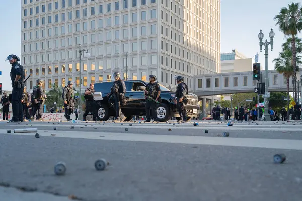 Los Angeles, ABD, 8 Haziran 2025: Genişletilmiş ICE operasyonlarına ve göçmen haklarına karşı düzenlenen gösteride arka planda polis memurlarıyla birlikte yerde lastik mermi parçaları bulundu