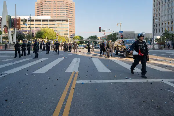 Los Angeles, ABD, 8 Haziran 2025: Genişletilmiş ICE operasyonlarına ve göçmen haklarına karşı düzenlenen gösteride arka planda polis memurlarıyla birlikte yerde lastik mermi parçaları bulundu