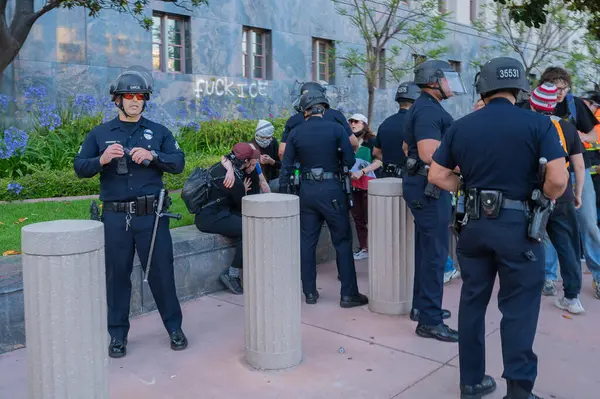Los Angeles, ABD, 8 Haziran 2025: Genişletilmiş ICE operasyonlarına karşı düzenlenen ve göçmen haklarına destek veren bir gösteride polis memurları tarafından çevrelenmiş yaralı protestocu