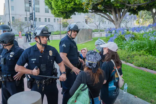 Los Angeles, ABD, 8 Haziran 2025: Genişletilmiş ICE operasyonlarına karşı düzenlenen ve göçmen haklarına destek veren bir gösteride polis memurları tarafından çevrelenmiş yaralı protestocu
