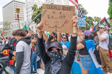 Los Angeles, Kaliforniya, ABD, 14 Temmuz 2025, Hükümetin politikalarını protesto eden ve demokrasi ve göçmen haklarını destekleyen protestocular ellerinde sloganlar tutuyorlar..