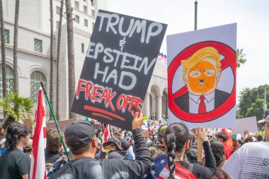 Los Angeles, Kaliforniya, ABD, 14 Temmuz 2025, Hükümetin politikalarını protesto eden ve demokrasi ve göçmen haklarını destekleyen protestocular ellerinde sloganlar tutuyorlar..