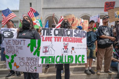 Los Angeles, Kaliforniya, ABD, 14 Temmuz 2025, Hükümetin politikalarını protesto eden ve demokrasi ve göçmen haklarını destekleyen protestocular ellerinde sloganlar tutuyorlar..