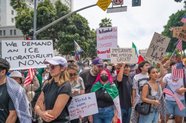 Los Angeles, Kaliforniya, ABD, 14 Temmuz 2025, Hükümetin politikalarını protesto eden ve demokrasi ve göçmen haklarını destekleyen protestocular ellerinde sloganlar tutuyorlar..