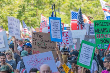 Los Angeles, Kaliforniya, ABD, 14 Temmuz 2025, Hükümetin politikalarını protesto eden ve demokrasi ve göçmen haklarını destekleyen protestocular ellerinde sloganlar tutuyorlar..