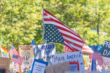 Los Angeles, Kaliforniya, ABD, 14 Temmuz 2025, Hükümetin politikalarını protesto eden ve demokrasi ve göçmen haklarını destekleyen protestocular ellerinde sloganlar tutuyorlar..
