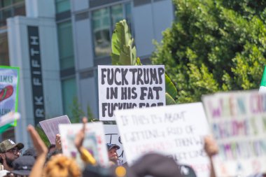 Los Angeles, Kaliforniya, ABD, 14 Temmuz 2025, Hükümetin politikalarını protesto eden ve demokrasi ve göçmen haklarını destekleyen protestocular ellerinde sloganlar tutuyorlar..