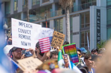 Los Angeles, Kaliforniya, ABD, 14 Temmuz 2025, Hükümetin politikalarını protesto eden ve demokrasi ve göçmen haklarını destekleyen protestocular ellerinde sloganlar tutuyorlar..