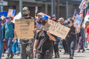 Los Angeles, Kaliforniya, ABD, 14 Temmuz 2025, Hükümetin politikalarını protesto eden ve demokrasi ve göçmen haklarını destekleyen protestocular ellerinde sloganlar tutuyorlar..