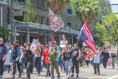Los Angeles, Kaliforniya, ABD, 14 Temmuz 2025, Hükümetin politikalarını protesto eden ve demokrasi ve göçmen haklarını destekleyen protestocular ellerinde sloganlar tutuyorlar..