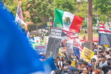Los Angeles, Kaliforniya, ABD, 14 Temmuz 2025, Hükümetin politikalarını protesto eden ve demokrasi ve göçmen haklarını destekleyen protestocular ellerinde sloganlar tutuyorlar..