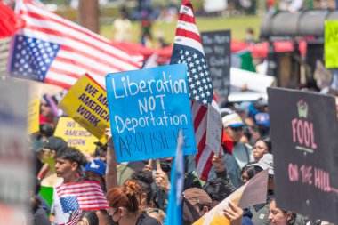 Los Angeles, Kaliforniya, ABD, 14 Temmuz 2025, Hükümetin politikalarını protesto eden ve demokrasi ve göçmen haklarını destekleyen protestocular ellerinde sloganlar tutuyorlar..