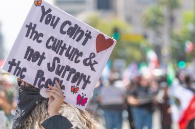 Los Angeles, Kaliforniya, ABD, 14 Temmuz 2025, Hükümetin politikalarını protesto eden ve demokrasi ve göçmen haklarını destekleyen protestocular ellerinde sloganlar tutuyorlar..