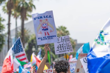 Los Angeles, Kaliforniya, ABD, 14 Temmuz 2025, Hükümetin politikalarını protesto eden ve demokrasi ve göçmen haklarını destekleyen protestocular ellerinde sloganlar tutuyorlar..