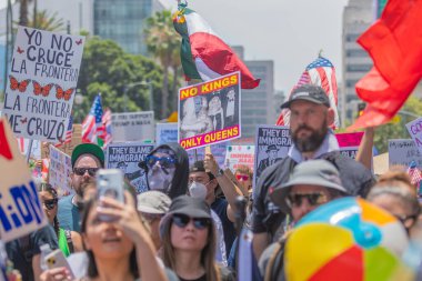 Los Angeles, Kaliforniya, ABD, 14 Temmuz 2025, Hükümetin politikalarını protesto eden ve demokrasi ve göçmen haklarını destekleyen protestocular ellerinde sloganlar tutuyorlar..